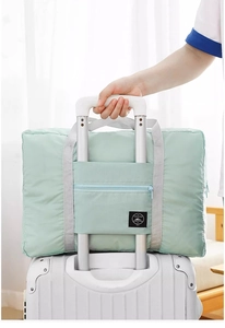 Travel luggage bag attached to suitcase handle showing trolley sleeve functionality