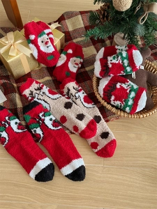 Close-up of thick coral fleece Christmas socks with 3D Santa and reindeer designs