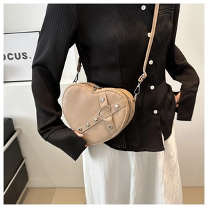 Détail du sac à main coeur kaki avec rivets argentés et anneau métallique sur cuir mat