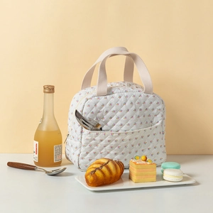 Primer plano de bolsa térmica acolchada con flores y bolsillo frontal para cubiertos