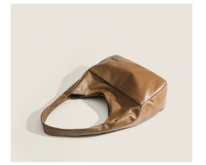 Detail view of the brown leather shoulder bag with soft texture and minimalist hardware