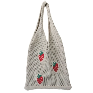 Close-up of beige knitted tote bag featuring red strawberry embroidery and mesh texture