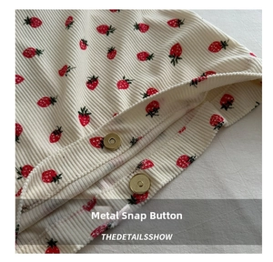 Detail of magnetic snap closures on white corduroy tote bag with strawberry print