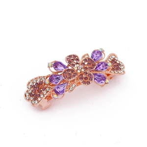 Detailed macro of rose gold butterfly hair clip with purple and clear rhinestones