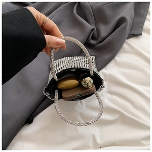 Detailed internal view of silver rhinestone handbag showing capacity for phone and perfume