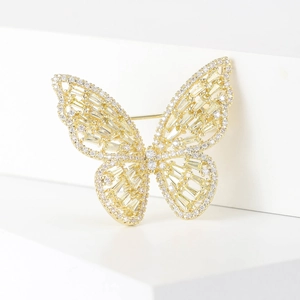 Close-up of golden butterfly brooch with micro-pave zircons and hollow wing design