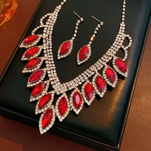 Luxurious red teardrop necklace and earring set with crystals on a jewelry display