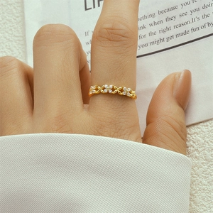 Close-up of gold 925 silver double layer cross ring with cubic zirconia on finger