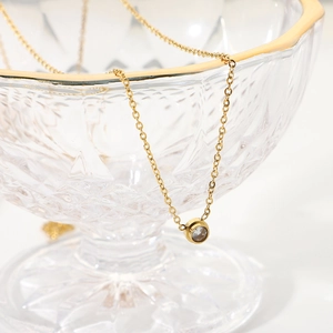 Elegant 18K gold plated necklace with a round zircon pendant on a glass rim