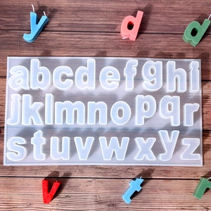 Macro detail of translucent silicone alphabet mold with colorful letter candles on wood