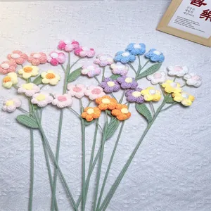Flat lay of colorful handmade crochet flowers with detailed knitted petals and green stems