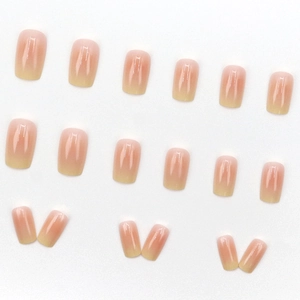Short square press-on nails featuring a soft peach to yellow gradient with a glossy finish