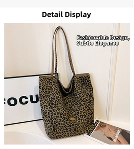 Detail of leopard print tote bag with metallic logo emblem and slender shoulder straps