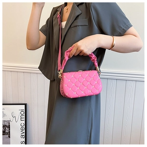 Detail of rose pink crossbody bag with pleated handle and golden flower studs