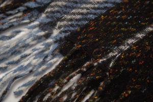 Detailed close-up of soft knitted scarf textures with fringe and striped pattern