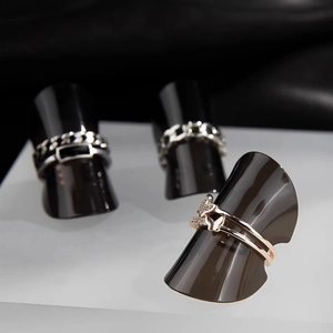 Rose gold butterfly ring and silver chain rings on black geometric cone displays