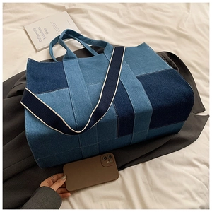 Detail of large denim patchwork tote bag showing spacious interior with phone for size