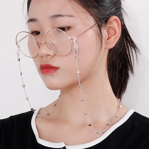 Silver stainless steel eyewear chain with star charms worn by model on white background