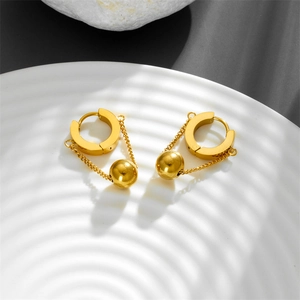 Minimalist stainless steel gold hoop earrings with chain and sphere drop on a white tray