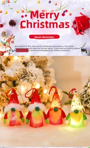 Close-up of lighted Christmas gnome pendants with sequined hats and glowing LED plush bodies
