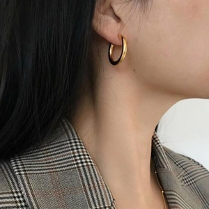 Classic golden thick hoop earrings worn by model with professional office attire