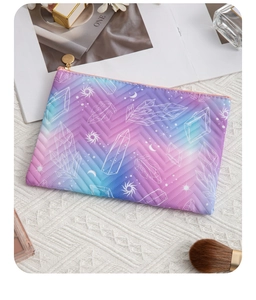 Detailed top view of a quilted gradient cosmetic bag with gold zipper and star patterns