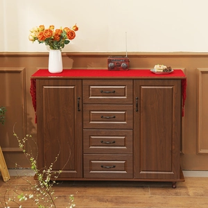 Red Christmas lace table runner with decorative tassels on a dark wood cabinet