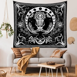 Macro shot of gothic tarot tapestry with skeleton and moon phases over a grey sofa