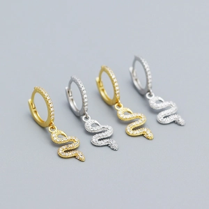 Macro view of snake drop earrings in gold and silver finish with zircon paving