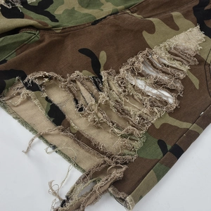 Gros plan sur le short camouflage avec finitions usées et bords effilochés