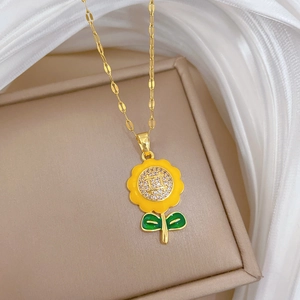 Detailed macro shot of sunflower pendant with yellow petals and crystal core on gold chain