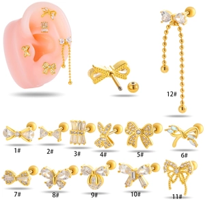 Twelve gold bow and butterfly cartilage studs with inlaid zircons shown on white background