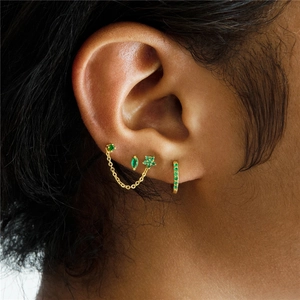 Macro detail of emerald earring set with marquise cut stones and gold plating