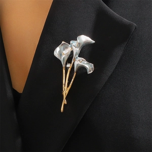 Calla lily brooch in gold and silver finish with rhinestones on black blazer lapel