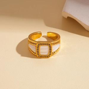 Détail d'une bague dorée vintage avec insert rectangulaire blanc et zircons sertis