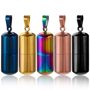 Polished stainless steel pill capsule pendants in five colors on a white background