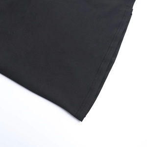 Détail de l'ourlet à double couture sur la robe longue noire en dentelle moulante