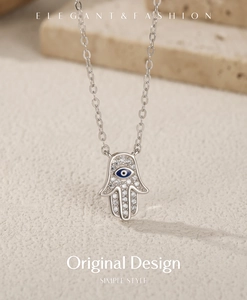 Vue détaillée du pendentif Main de Hamsa en argent S925 avec œil bleu et cristaux clairs
