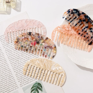 Acetate marble pattern wide-tooth hair combs set displayed on a book and tray