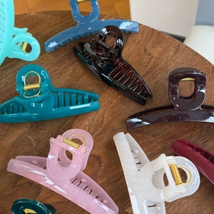 Close-up of large acrylic butterfly hair claws in various colors on a wooden surface