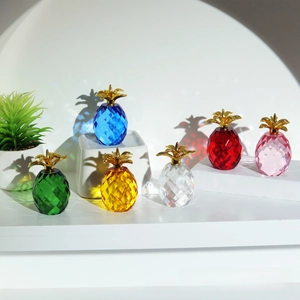 Set of six colorful faceted crystal pineapples with gold leaves on a clean background