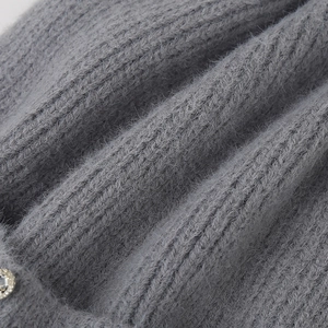 Detailed close-up of grey ribbed knit beanie fabric with soft mohair and crystal leaf stud