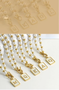 Detail of OT toggle clasp pearl necklaces with square shell initial letter pendants