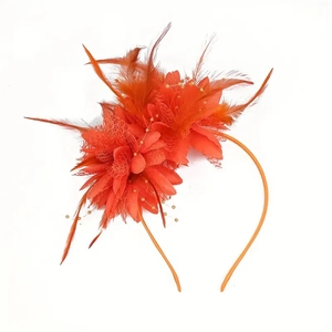 Close-up of orange fascinator headband with mesh veil feathers and floral accents