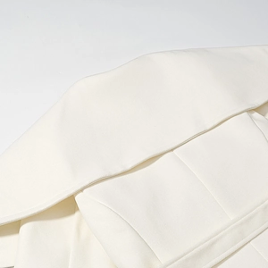 Detail of warm white wool coat lapel showing clean stitching and high quality texture