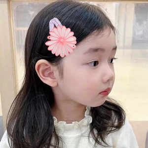Primer plano de una niña con una pinza de pelo de margarita de doble capa rosa y violeta