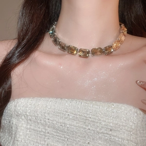 Close-up of champagne square-cut crystal necklace on model for elegant jewelry styling