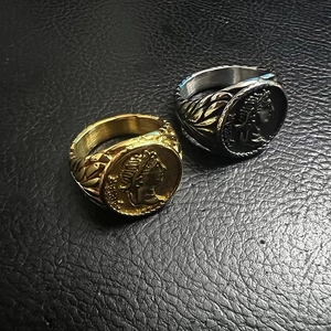 Detail view of gold and silver vintage Roman Caesar coin rings on black leather texture