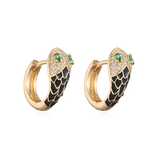 Close-up of gold snake earrings with black enamel and white zircon stones