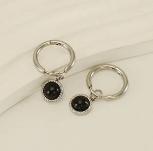 Vue détaillée des boucles d'oreilles en acier inoxydable avec pendentifs noirs polis